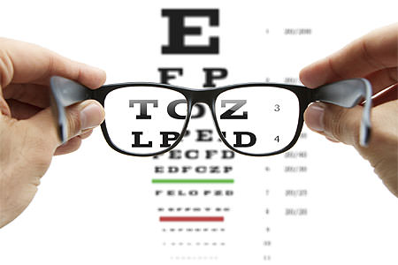 Looking through eyeglasses at eye chart