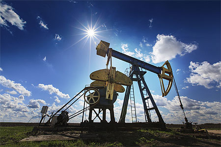 Oil rig with sun and blue sky