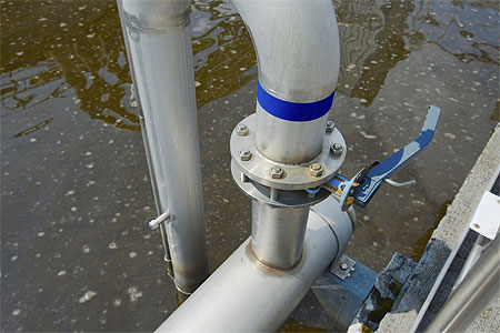 Wastewater treatment aeration basin with pipe in foreground